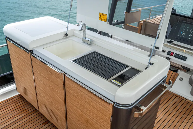 Slide: The Image of Outdoor kitchen on 2024 Prestige X60 yacht with sink and grill, overlooking the ocean. - 15