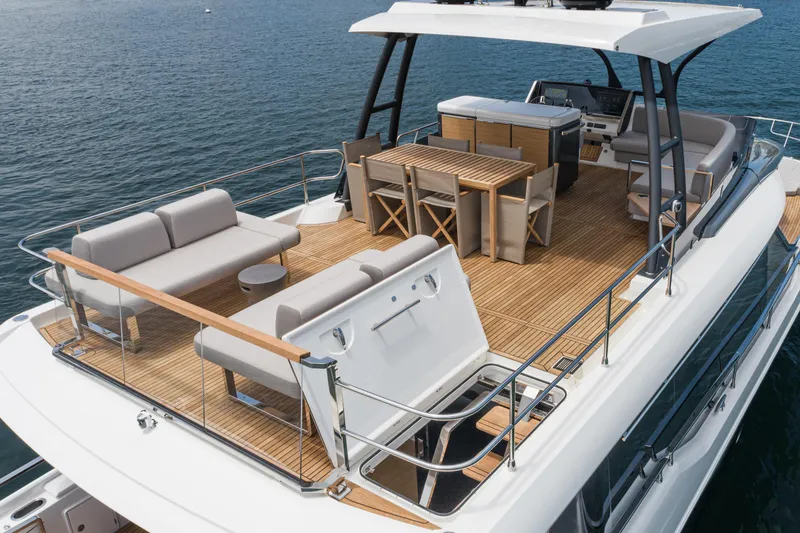 Slide: The Image of 2024 Prestige X60 yacht deck with elegant seating and dining area on the water. - 22