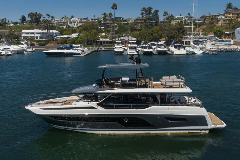 Slide: The Image of 2024 Prestige X60 yacht cruising in a marina with luxury boats and waterfront homes. - 3