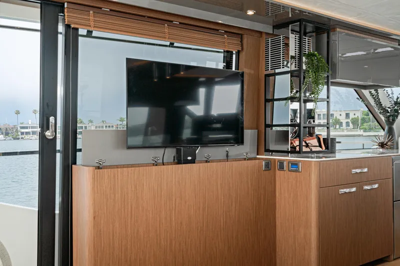 Slide: The Image of 2024 Prestige X60 yacht interior with modern TV setup and elegant wood cabinetry. - 34
