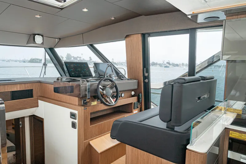 Slide: The Image of 2024 Prestige X60 yacht interior with modern helm, luxurious seating, and panoramic windows. - 38