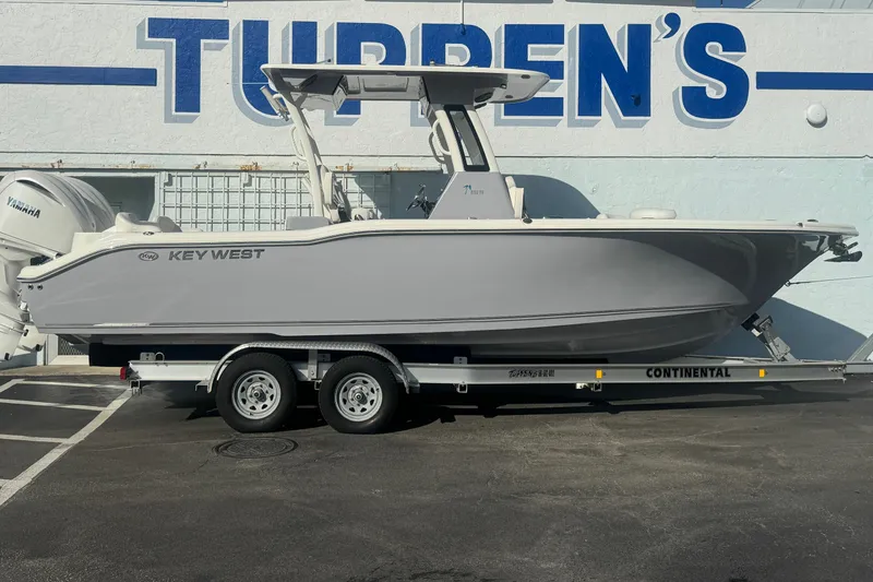 Slide: The Image of 2026 Key West 263 FS boat on trailer, parked outside a building. - 1