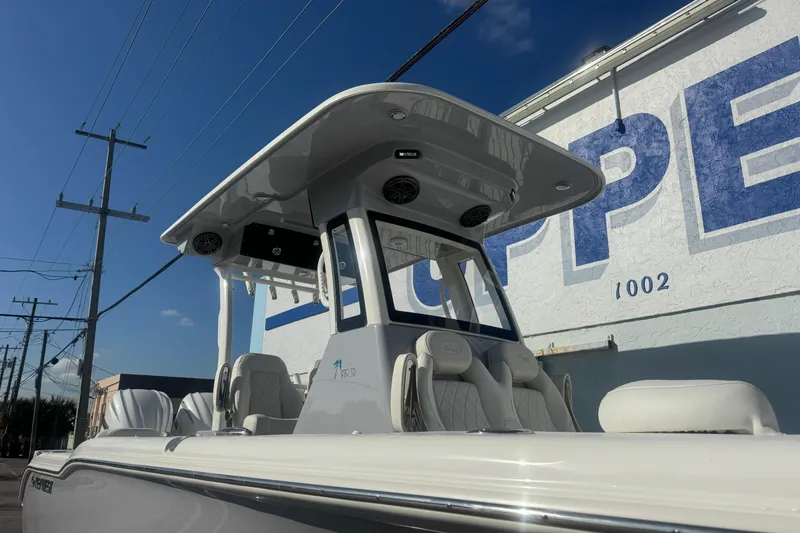 Slide: The Image of 2026 Key West 263 FS boat with T-top, parked near a building under clear blue sky. - 3