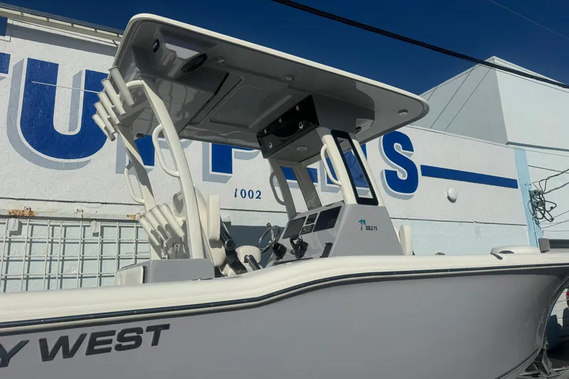 Slide: The Image of 2026 Key West 263 FS boat with T-top, parked near a building. - 4