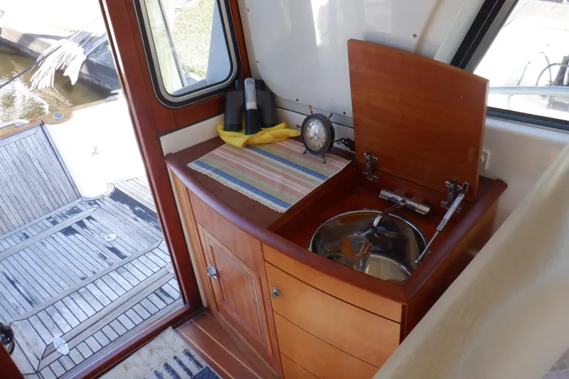 Slide: The Image of 2001 Linssen DS 45 yacht deck with open storage compartment, wooden flooring, and scenic water view. - 21