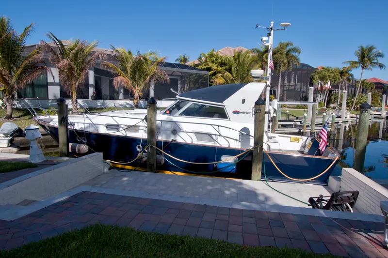 Slide: The Image of 2001 Linssen DS 45 yacht docked by palm trees and waterfront homes. - 77