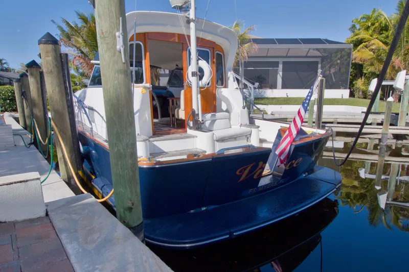 Slide: The Image of Linssen DS 45 yacht from 2001 docked, featuring American flag and sunny surroundings. - 78