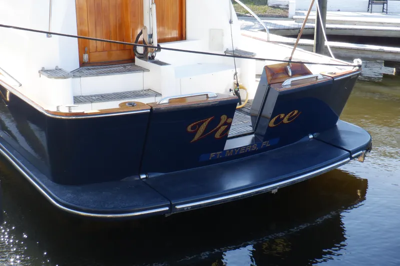 Slide: The Image of 2001 Linssen DS 45 yacht cruising on open water, rear view with American flag. - 8