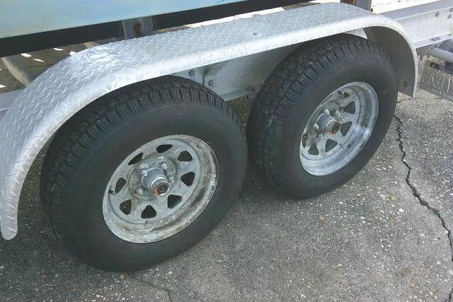 Slide: The Image of Trailer wheels for 2002 Everglades 250 Center Console boat on concrete surface. - 54