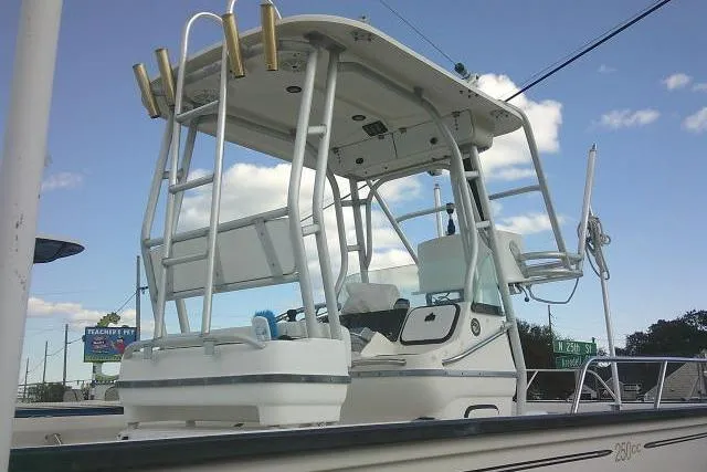 Slide: The Image of 2002 Everglades 250 Center Console boat with T-top and rod holders under a clear sky. - 57