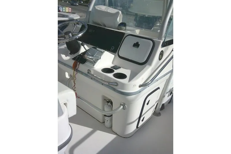 Slide: The Image of 2002 Everglades 250 Center Console boat dashboard with steering wheel and controls. - 58