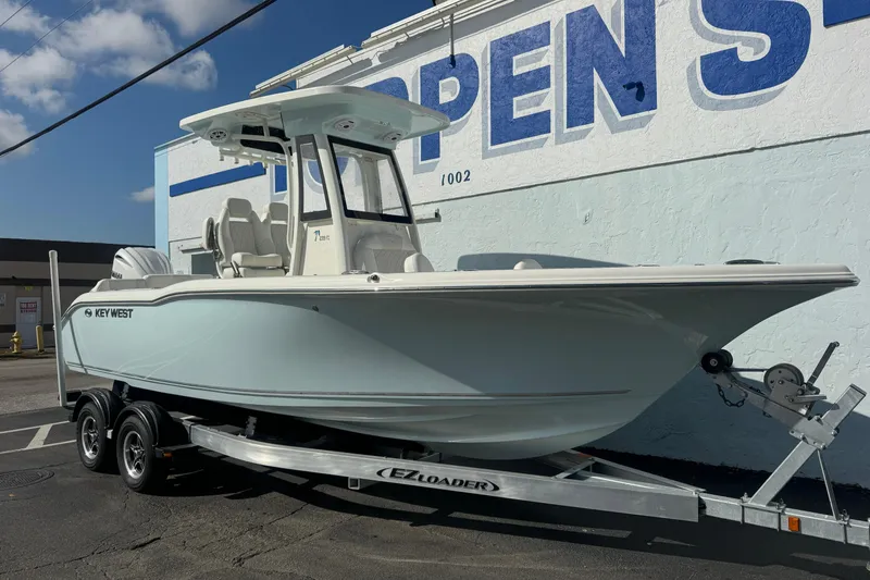 Slide: The Image of 2026 Key West 239 FS boat on trailer, parked outdoors near a building. - 2