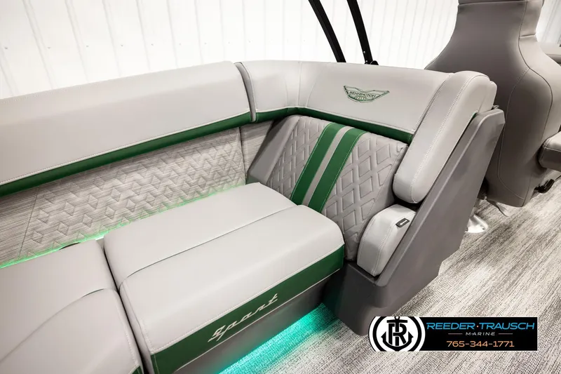 Slide: The Image of 2026 Bennington MOFBSF boat interior with gray and green seating, featuring quilted design and logo. - 26