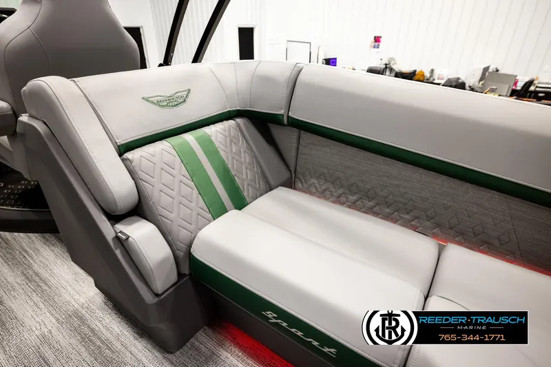 Slide: The Image of 2026 Bennington MOFBSF boat interior with gray and green seating, Reeder-Trausch Marine logo. - 28