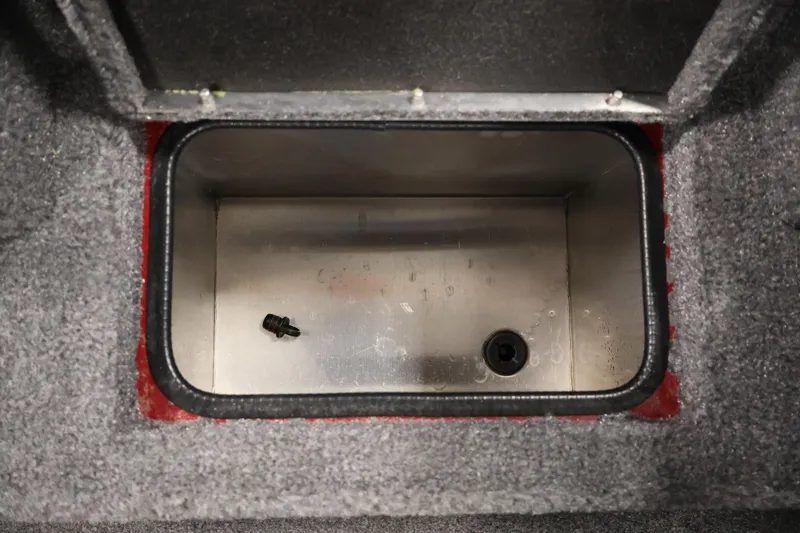 Slide: The Image of 2024 Tracker Pro Team 175 TXW storage compartment with carpeted interior and metal base. - 15