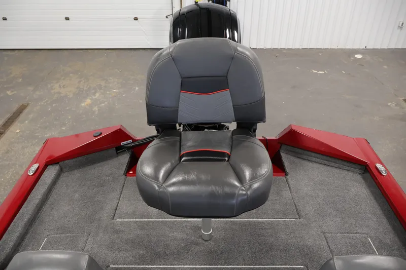 Slide: The Image of 2024 Tracker Pro Team 175 TXW boat seat, gray and red design, in a garage setting. - 24