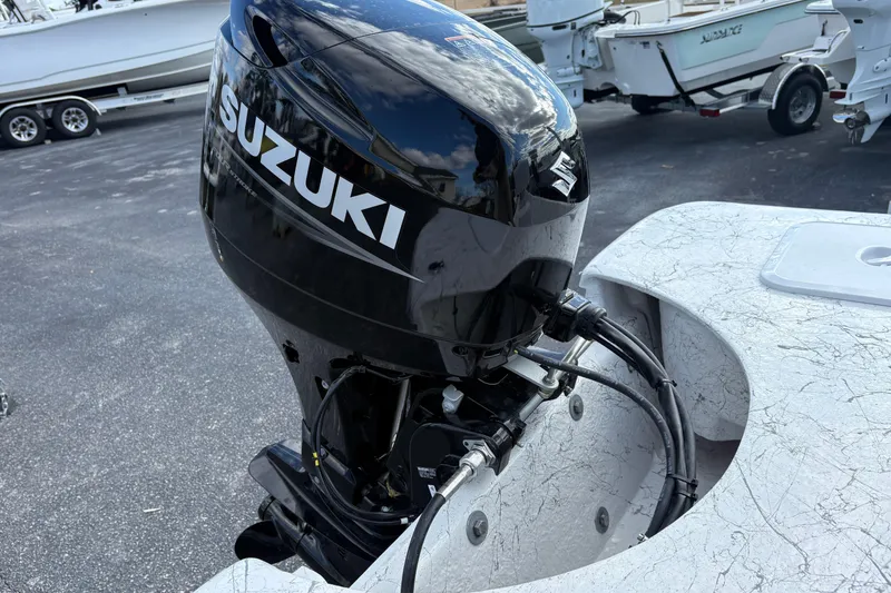 Slide: The Image of 2026 Coastal Skiff 171 with Suzuki outboard motor in a marina setting. - 12