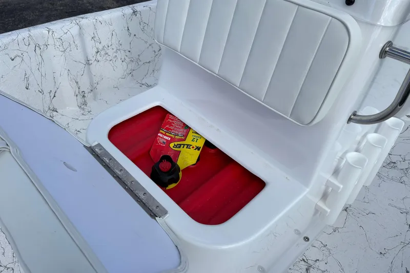 Slide: The Image of Storage compartment in 2026 Coastal Skiff 171 boat with red interior and cleaning supplies. - 14