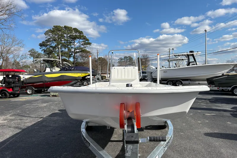 Slide: The Image of 2026 Coastal Skiff 171 boat on trailer under a blue sky with clouds. - 3
