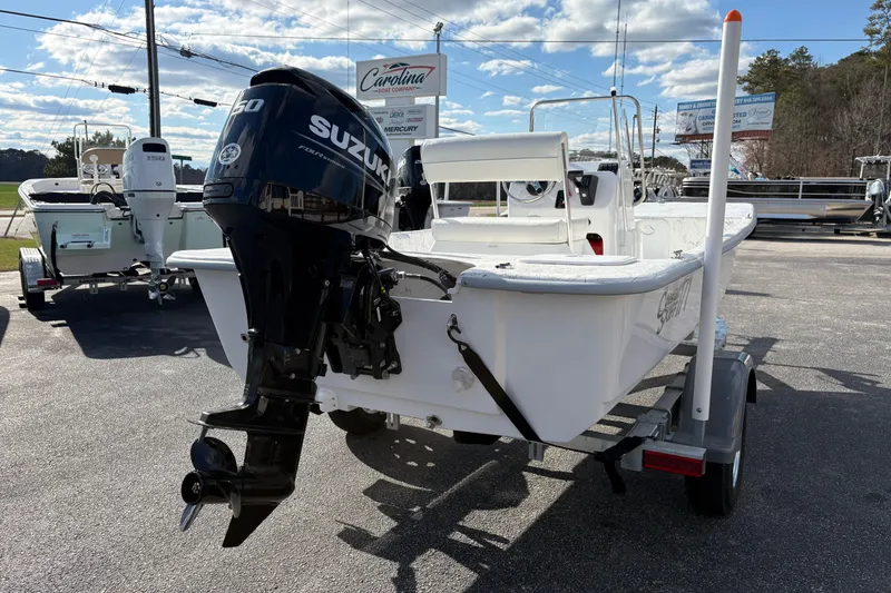 Slide: The Image of 2026 Coastal Skiff 171 with Suzuki outboard motor on trailer, parked outdoors. - 5
