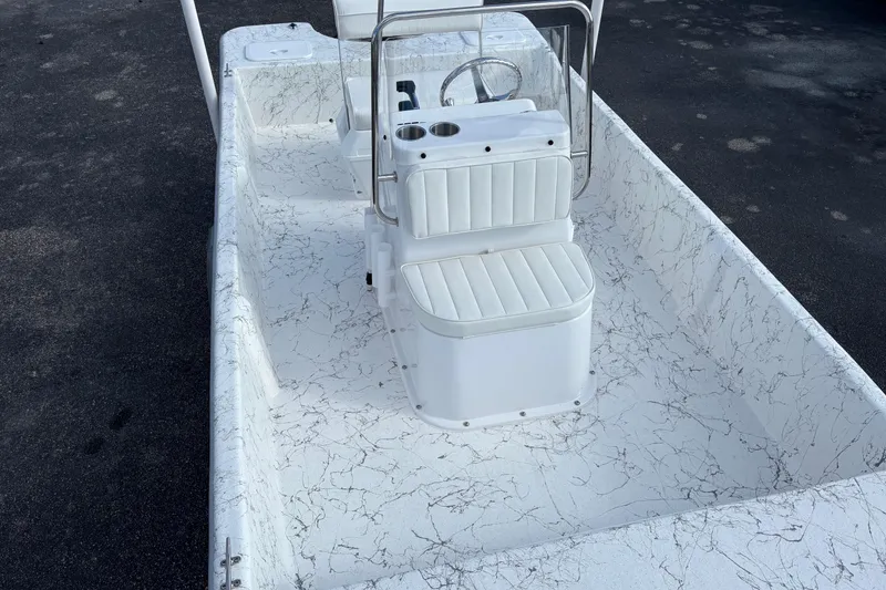 Slide: The Image of 2026 Coastal Skiff 171 boat interior with white seating and marbled flooring. - 7