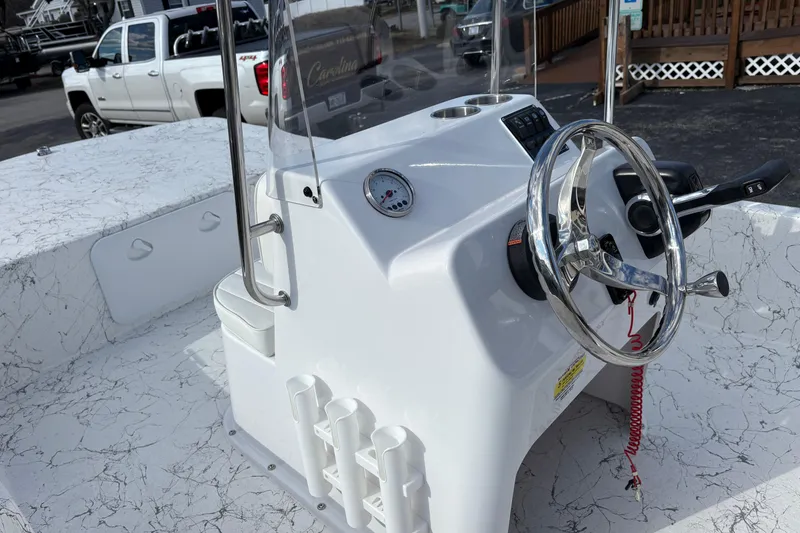 Slide: The Image of 2026 Coastal Skiff 171 boat console with steering wheel and controls, featuring a sleek design. - 9