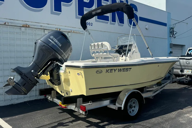 Slide: The Image of 2026 Key West 179 FS boat with Yamaha engine on trailer, parked outside a building. - 2