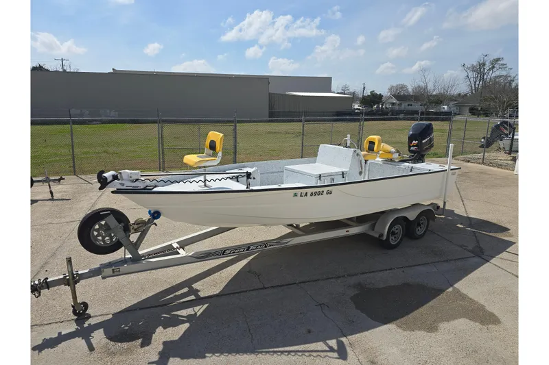Slide: The Image of 2011 Reno Skiff 22 boat on trailer, parked outdoors under a clear sky. - 7