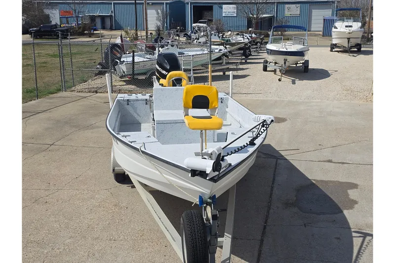 Slide: The Image of 2011 Reno Skiff 22 boat with yellow seat on trailer in a boatyard. - 8