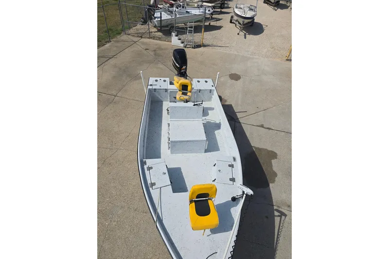 Slide: The Image of 2011 Reno Skiff 22 boat with yellow seats, parked on concrete. - 9