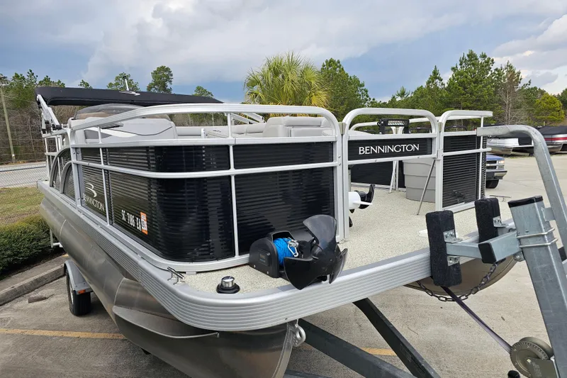 Slide: The Image of 2020 Bennington SV 20 SFV pontoon boat on trailer, parked outdoors. - 2