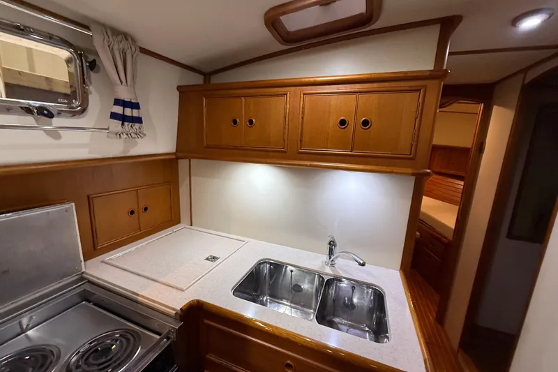 Slide: The Image of 2000 Grand Banks 43 Eastbay FB yacht kitchen with wooden cabinets and dual sink. - 101