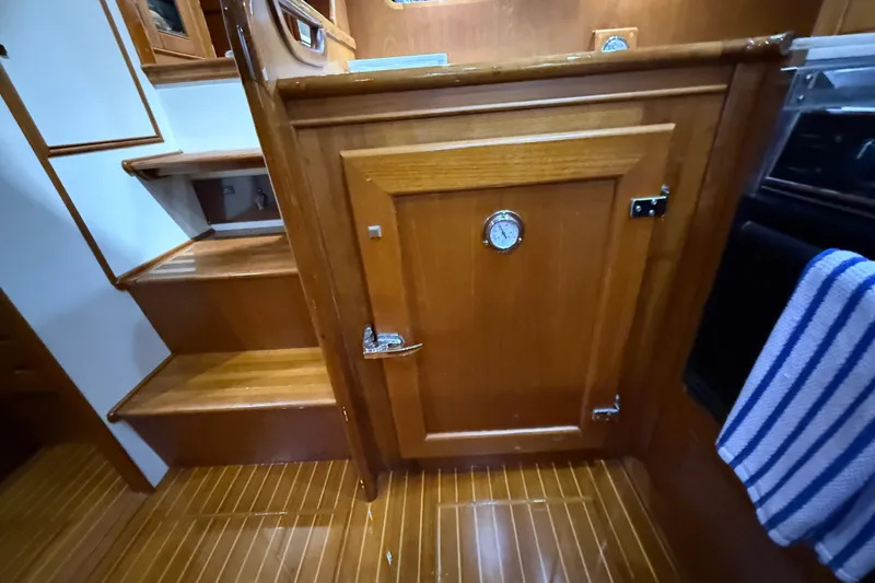 Slide: The Image of Interior of 2000 Grand Banks 43 Eastbay FB, featuring wooden cabinetry and stairs. - 103