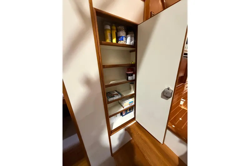 Slide: The Image of Storage cabinet inside 2000 Grand Banks 43 Eastbay FB yacht, featuring organized shelves with various items. - 106