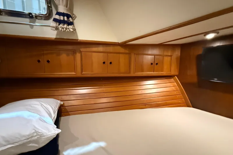 Slide: The Image of Cozy cabin interior of 2000 Grand Banks 43 Eastbay FB with wooden cabinetry and bed. - 119