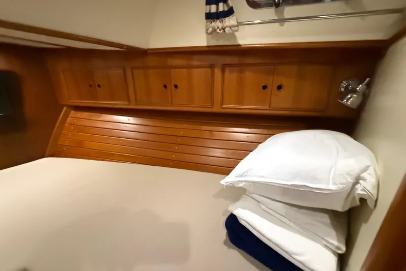 Slide: The Image of Cozy cabin interior of 2000 Grand Banks 43 Eastbay FB with wooden cabinetry and bedding. - 121