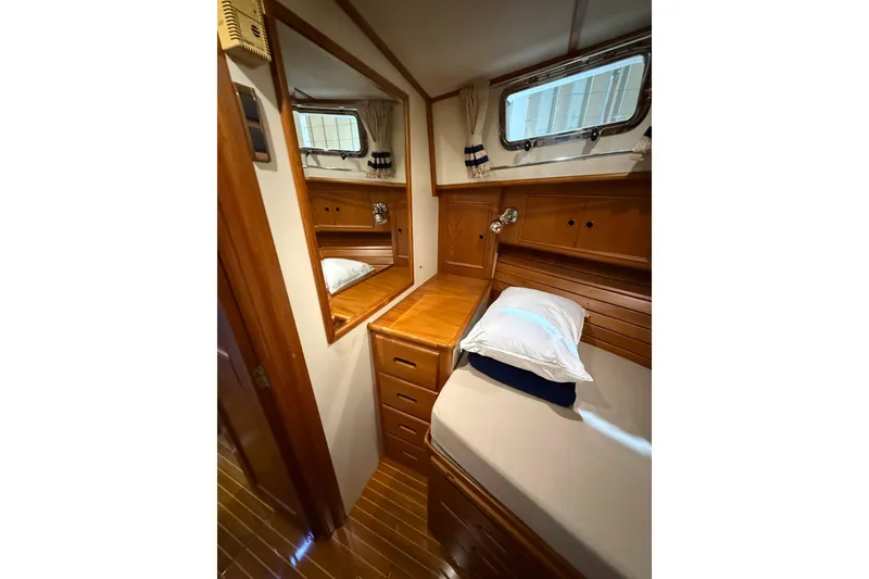 Slide: The Image of Cozy cabin interior of 2000 Grand Banks 43 Eastbay FB with wooden furnishings and bedding. - 122