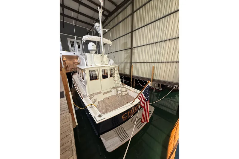 Slide: The Image of 2000 Grand Banks 43 Eastbay FB docked indoors with American flag displayed. - 29