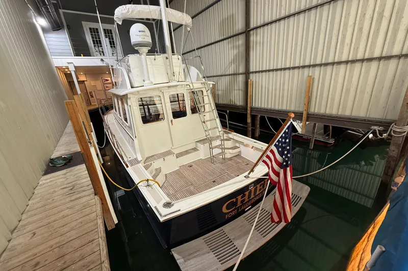 Slide: The Image of 2000 Grand Banks 43 Eastbay FB docked indoors with American flag. - 30