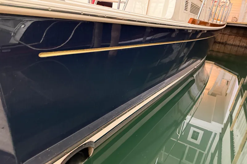 Slide: The Image of 2000 Grand Banks 43 Eastbay FB yacht side view, docked in calm water. - 35