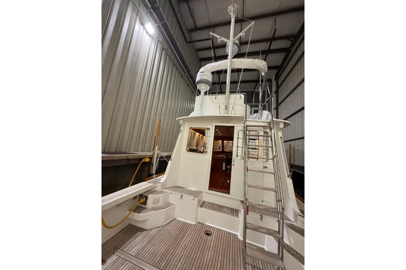 Slide: The Image of 2000 Grand Banks 43 Eastbay FB yacht in storage, showcasing rear deck and ladder. - 36