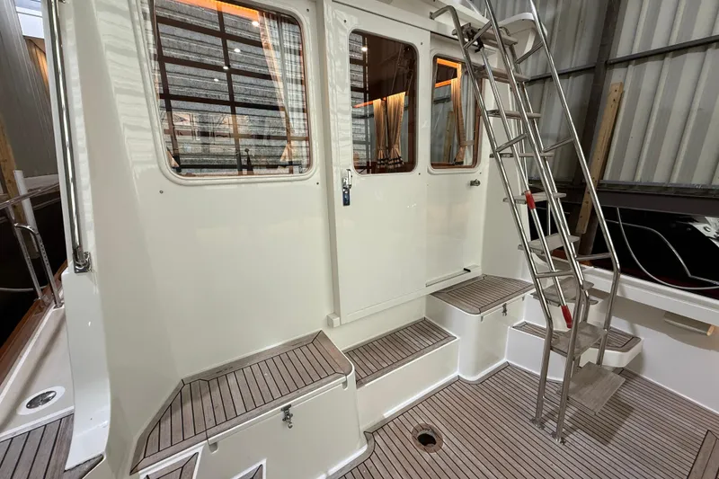 Slide: The Image of 2000 Grand Banks 43 Eastbay FB yacht with teak deck and metal ladder in a marina. - 38