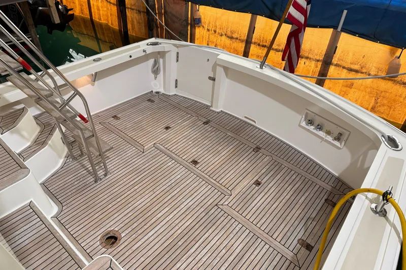 Slide: The Image of Cockpit of 2000 Grand Banks 43 Eastbay FB with teak flooring and American flag. - 40