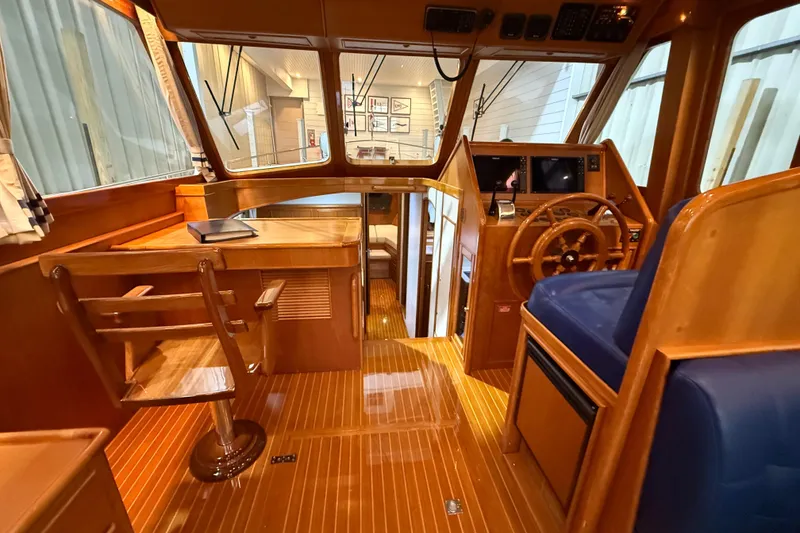 Slide: The Image of 2000 Grand Banks 43 Eastbay FB yacht interior with wooden helm and blue seating. - 69