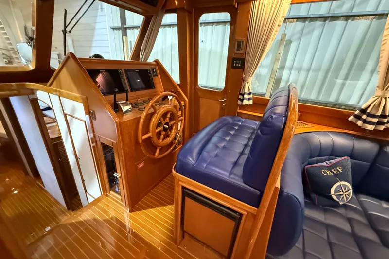 Slide: The Image of Interior of 2000 Grand Banks 43 Eastbay FB with wooden helm and blue seating. - 70