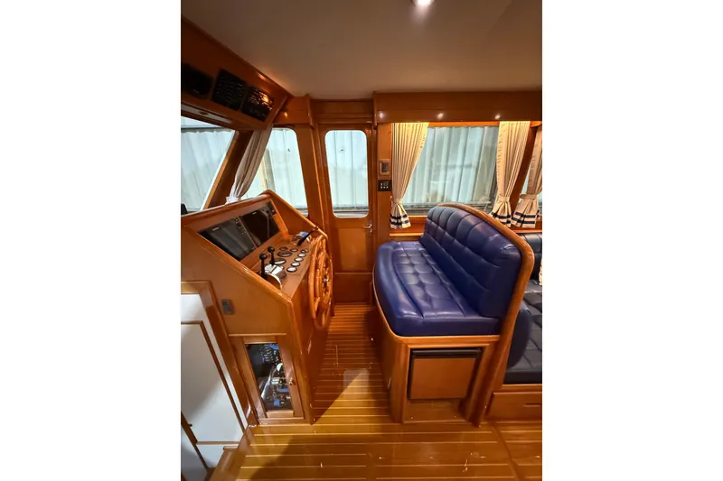 Slide: The Image of Interior of 2000 Grand Banks 43 Eastbay FB with blue seating and wooden helm. - 71
