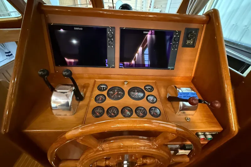 Slide: The Image of Helm of 2000 Grand Banks 43 Eastbay FB with dual Simrad displays and classic wooden wheel. - 76