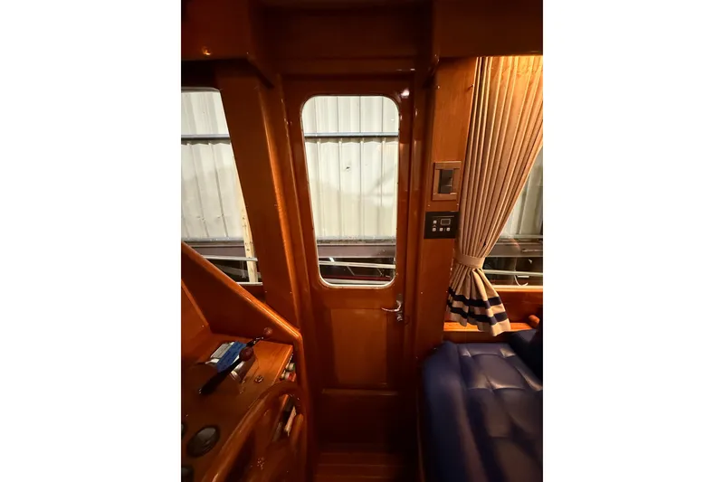 Slide: The Image of Interior view of 2000 Grand Banks 43 Eastbay FB with wooden door and blue seating. - 80