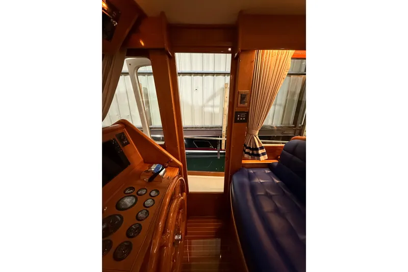 Slide: The Image of Interior view of 2000 Grand Banks 43 Eastbay FB yacht with wooden dashboard and blue seating. - 81