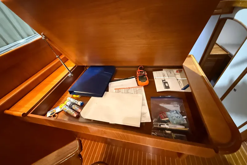 Slide: The Image of Open wooden desk on 2000 Grand Banks 43 Eastbay FB with documents and tools. - 87